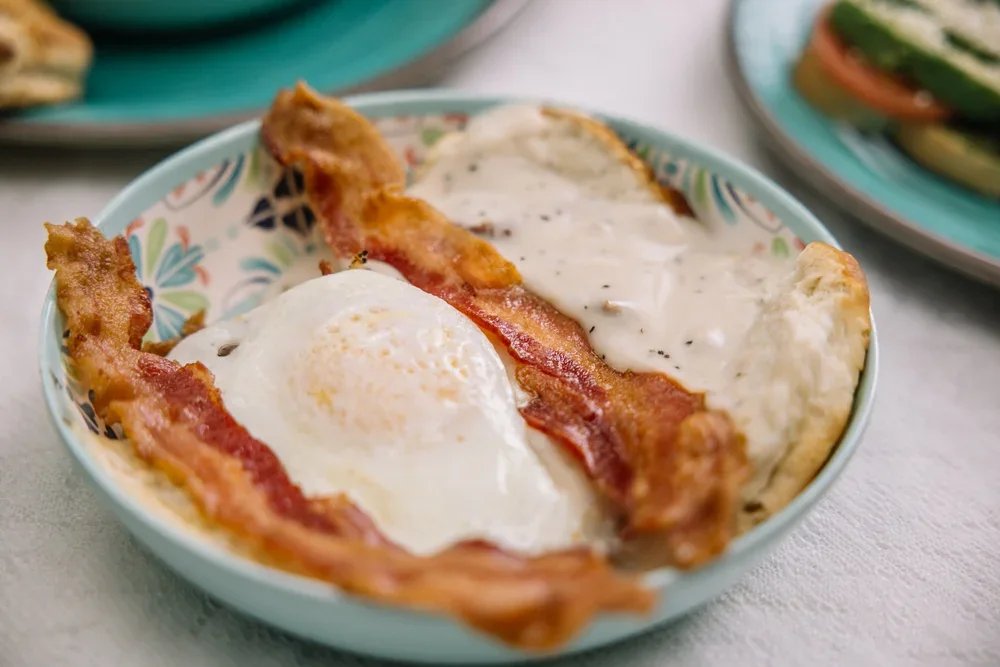 Egg and bacon over a biscuit with sausage gravy
